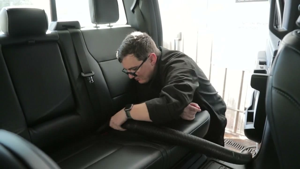 Nick carefully vacuuming the inside of a vehicle